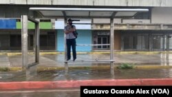 Un hombre se encarama sobre una banca en una parada del transporte en Maracaibo, Zulia, durante un chubasco, el 2 de junio de 2023. Las autoridades esperan fuertes lluvias en el norte de Venezuela, especialmente en los estados Zulia y Falcón, por el paso de Bret por el Caribe.