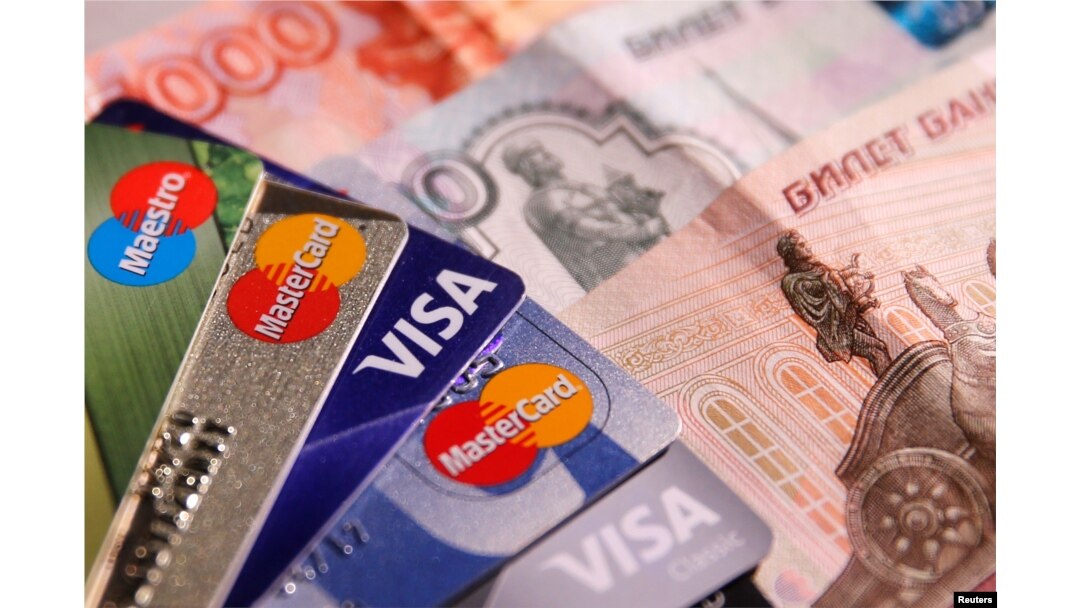 Gambar ilustrasi - Kartu kredit MasterCard, VISA dan Maestro dengan uang kertas rubel Rusia, 9 Juni 2016. (REUTERS/Maxim Zmeyev)