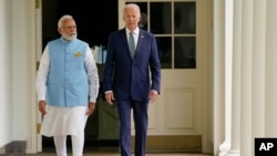 美国总统拜登在白宫南草坪为到访的印度总理纳伦德拉·莫迪举行国事访问欢迎仪式后与他沿着柱廊走向椭圆形办公室。（2023年6月22日）