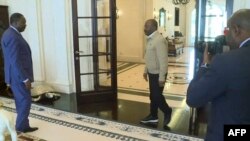 FILE - This video grab obtained by AFPTV from X, formerly Twitter, account @TVGABON24 on September 6, 2023 shows deposed president of Gabon, Ali Bongo Ondimba (C), receiving Abdou Abarry (L), head of the U.N. office for Central Africa, at his residence in Libreville.