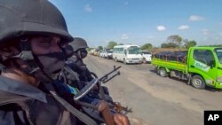 FILE - In this image made from video, police patrol a road in Palma, Cabo Delgado province, Mozambique, Aug. 15, 2021. The United Nations says jihadist violence in the region has forced more than a million people to flee their homes. 