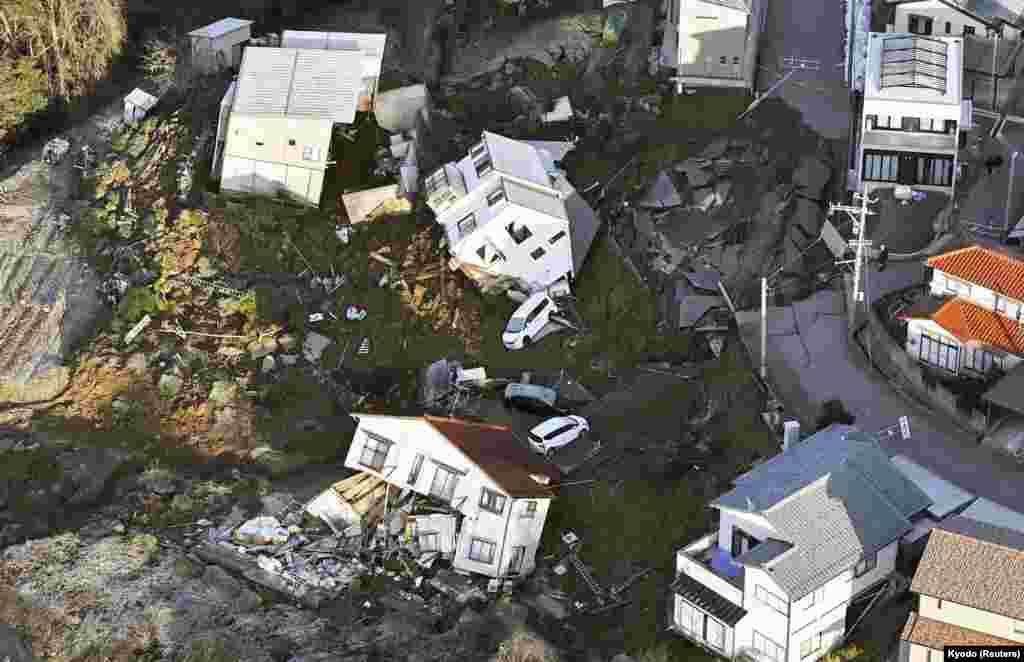 This image from above shows collapsed houses, cars and roads caused by an earthquake in Kanazawa, Ishikawa prefecture, Japan, in this photo released by Kyodo.
