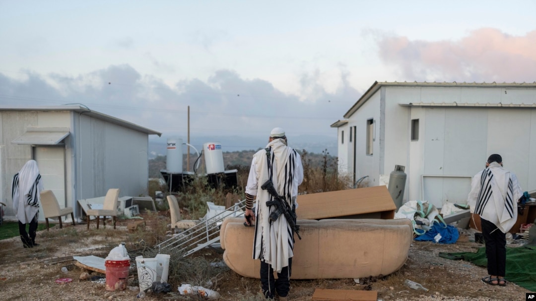 Para pemukim Israel berdoa di area permukiman Eviatar di Tepi Barat dalam doa pagi yang menyerukan legalisasi permukiman tersebut, pada 7 Juli 2024. (Foto: AP/Ohad Zwigenberg)