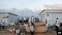 Para pemukim Israel berdoa di area permukiman Eviatar di Tepi Barat dalam doa pagi yang menyerukan legalisasi permukiman tersebut, pada 7 Juli 2024. (Foto: AP/Ohad Zwigenberg)