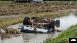 This photo shows a car flipped in floodwater in the aftermath of Cyclone Gabrielle near Napier, New Zealand, Feb. 16, 2023.
