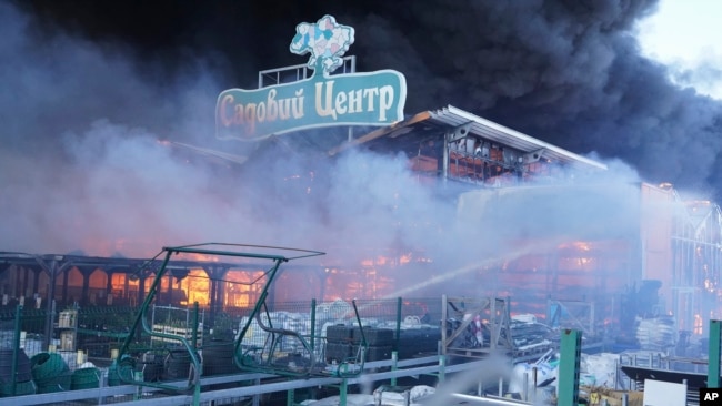 FILE - Firefighters put out a fire after two guided bombs hit a large construction supplies store in Kharkiv, Ukraine, May 25, 2024. The sign reads "Garden Center." Russia's war on Ukraine is among top foreign policy concerns among U.S. voters in the November election.