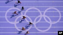 Sha'carri Richardson, right, of the United States, runs in women's 100-meter heat at the 2024 Summer Olympics, in Saint-Denis, France.