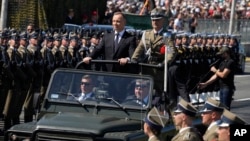 Poland's President Andrzej Duda greets troops as he arrives for a massive military parade that was to show Poland's defense potential as war is raging in neighboring Ukraine, in Warsaw, Poland, on Aug. 15, 2023.