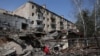 一名妇女站在乌克兰顿涅茨克州科斯特扬蒂尼夫卡镇被炸毁的一片建筑废墟中。（2024年4月11日）