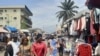 People look on at a market on the side of a road in Libreville on Sept. 2, 2023. There were demonstrations this week in the Gabonese cities of Libreville, Oyem and Franceville, as civil society groups call for an end to sanctions. 