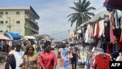 People look on at a market on the side of a road in Libreville on Sept. 2, 2023. There were demonstrations this week in the Gabonese cities of Libreville, Oyem and Franceville, as civil society groups call for an end to sanctions. 