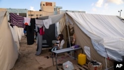 Palestinians displaced by the Israeli bombardment of the Gaza Strip sit in a UNDP-provided tent camp in Khan Younis, Oct. 19, 2023.