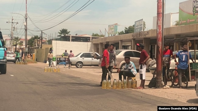Revendedores de gasolina se instalan en varios puntos de una calle en Maracaibo, Venezuela, para ofrecer varios litros del combustible, el miércoles 14 de junio de 2023.