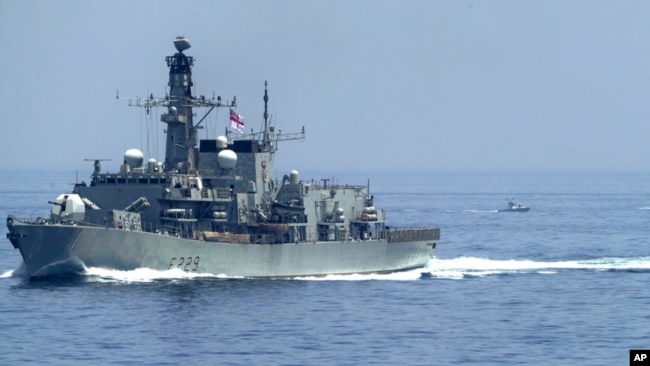 The British frigate HMS Lancaster sails as Iranian Revolutionary Guard vessels follow it in the Strait of Hormuz, May 19, 2023.