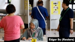 Para pemilih bersiap memberikan suaranya di tempat pemungutan suara saat pemilihan presiden di Singapura, 1 September 2023. (Foto: REUTERS/Edgar Su)