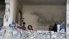 22일 가자지구 남부 라파에서 이스라엘 군의 공습이 계속되는 가운데 팔레스타인 어린이들이 이스라엘의 공습으로 파괴된 집에 앉아있다.