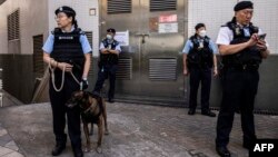 Polisi berjaga di dekat tempat pemungutan suara untuk pemilihan distrik di Hong Kong pada 10 Desember 2023. (ISAAC LAWRENCE / AFP)