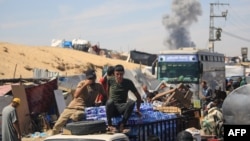 Una columna de humo se eleva tras un bombardeo israelí mientras palestinos desplazados se trasladan a Rafah, en el sur de la Franja de Gaza, el 31 de mayo de 2024.