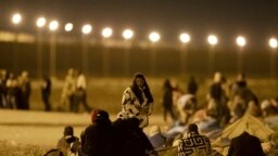 移民从墨西哥华雷斯城跨越边境后在一处边境围栏的入口等候入境。(2023年5月11日)