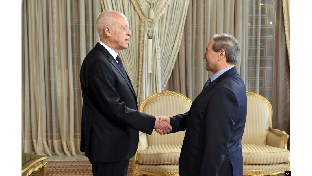Presiden Tunisia Kais Saied (kiri), berjabat tangan dengan Menteri Luar Negeri Suriah Faisal Mekdad di Carthage, dekat Tunis, Tunisia, Selasa, 18 April 2023. (Slim Abid/Kepresidenan Tunisia via AP)