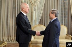 Presiden Tunisia Kais Saied (kiri), berjabat tangan dengan Menteri Luar Negeri Suriah Faisal Mekdad di Carthage, dekat Tunis, Tunisia, Selasa, 18 April 2023. (Slim Abid/Kepresidenan Tunisia via AP)