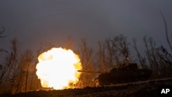 A Ukrainian tank towards fires towards Russian positions at the front line near Bakhmut, Ukraine, March 8, 2023.