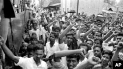 نو اپریل 1971 کے فائل فوٹو میں، مشرقی پاکستان کے گاؤں پنگسا کے لوگ بنگالی قوم پرست رہنما شیخ مجیب الرحمان اور ان کی پارٹی کی حمایت کے اظہار کے لیے نعرے لگا رہے ہیں۔ (اے پی فوٹو)
