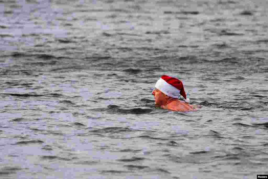 A member of the Berliner Seehunde (Berlin seals) ice swimmers club swims in the Oranke Lake during the traditional Christmas Day swimming event, in Berlin, Germany, Dec. 25, 2023. 