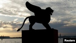 FILE - A statue of a lion, the symbol of the Venice Film Festival, is silhouetted in Venice August 28, 2012.