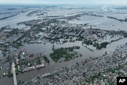 Houses are seen underwater and polluted by oil in a flooded neighbourhood in Kherson, Ukraine, Saturday, June 10, 2023.