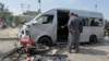 Pakistani investigators examine a damaged van at the site of a suicide attack in Karachi, Pakistan, April 19, 2024. 