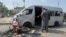 Pakistani investigators examine a damaged van at the site of a suicide attack in Karachi, Pakistan, April 19, 2024. 
