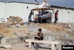 Dječak gleda kako se Palestinci pripremaju za bijeg iz Rafe nakon što su izraelske snage pokrenule kopnenu i zračnu operaciju u istočnom dijelu južnog grada Gaze, u Rafi, u južnom pojasu Gaze, 12. maja 2024.