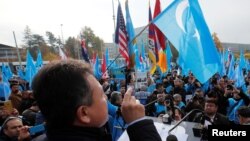 FILE - Dolkun Isa, president of the World Uyghur Congress, gestures as he speaks during a demonstration against China, in Geneva, Switzerland, Nov. 6, 2018. 