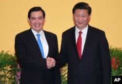 Ma Ying-jeou, kiri, dan Presiden China Xi Jinping berjabat tangan di Hotel Shangri-la pada 7 November 2015, di Singapura. (Foto: AP)