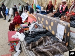 Sonam Wangchuk, lying under blankets, is surrounded by supporters on the 17th day of his hunger strike seeking protected status for the region’s people, land and ecology in Leh, India, March 22, 2024.