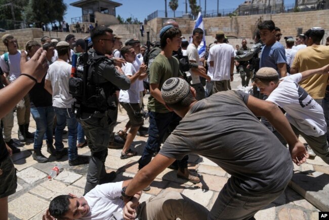 Israeli police officers separate Israelis and Palestinians in front of the Damascus Gate of Jerusalem's Old City shortly before a march through the area by Jewish nationalists in Jerusalem Day, June 5, 2024.