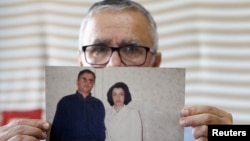 Taghi Ramahi, husband of Narges Mohammadi, a jailed Iranian women's rights advocate, who won the 2023 Nobel Peace Prize, poses with an undated photo of himself and his wife, in Paris, France, October 6, 2023.