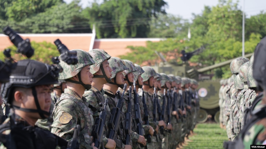 ទាហានខ្មែរនិងចិនឈរនៅក្នុងពិធីបើកសមយុទ្ធ «នាគមាស» ក្នុងខេត្តកំពង់ឆ្នាំង នាថ្ងៃទី១៦ ខែឧសភា ឆ្នាំ២០២៤។ (ស៊ុន ណារិន/វីអូអេ)