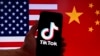 显示美国国旗和中国国旗的背景映衬着一台带有TikTok标识的苹果公司iPhone手机。（2023年3月16日）
