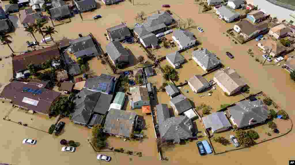 Floodwaters surround homes and vehicles in the community of Pajaro in Monterey County, California, March 13, 2023.