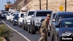 A member of the Hawaii National Guard helps control traffic leaving Lahaina on the island of Maui in the U.S. state of Hawaii, Aug. 11, 2023.