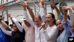 Venezuelan presidential candidate Edmundo Gonzalez Urrutia, center, and opposition leader Mariana Corina Machado, second right, attend the launch of his campaign for the upcoming election in La Victoria, Venezuela, May 18, 2024. 