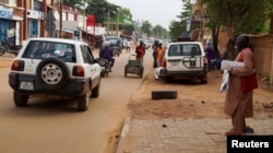 Muškarac stoji na trotoaru dok se vozila kreću ulicom u Nijameju, Niger, 2. augusta 2023.
