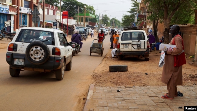 A man stands on a sidewalk, as vehicles move on a street in Niamey, Niger, Aug. 2, 2023. Niger is a key US partner in fighting Islamic extremism in the Sahel.