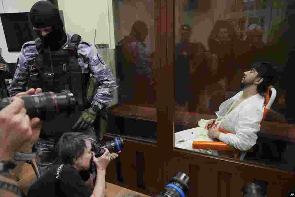 Muhammadsobir Faizov, a suspect in the Crocus City Hall shooting on Friday sits in a glass cage in the Basmanny District Court in Moscow, Russia, March 24, 2024. 
