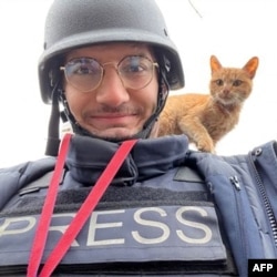 FILE - AFP journalist Arman Soldin snaps a selfie with a cat on his shoulder during an assignment for AFP in Ukraine.