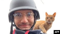 Jurnalis AFP Arman Soldin mengambil foto selfie bersama seekor kucing di sela penugasannya meliput perang di Ukraina. (Foto: AFP/Arman Soldin)