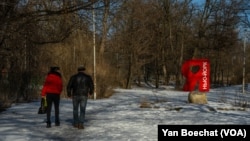 A couple passes by a landmark celebrating the love of the citizens for the little frontline city of New York in the Donetsk region, Ukraine, on Feb. 20, 2023.