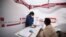 FILE - Gladys Rara undergoes screening before being tested for tuberculosis at a mobile clinic in Gugulethu township near Cape Town, South Africa, March 26, 2021. 